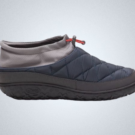 A navy and grey Chaco Rambler Puff Slipper on a grey background