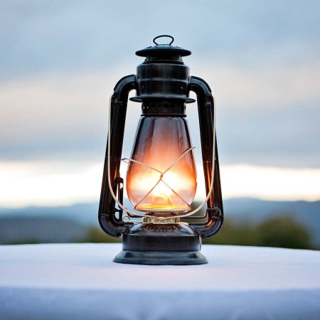 An antique gas lantern sits on a tabletop in the fading twilight. "Gaslighting" is Merriam-Webster's word of the year for 2022.