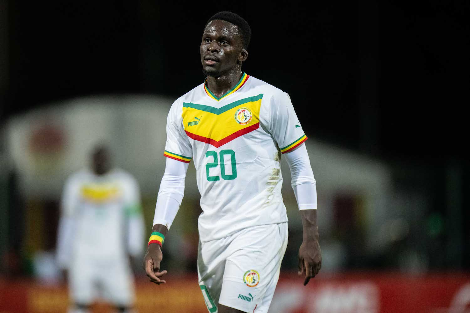 a senegal soccer player in a white jersey 