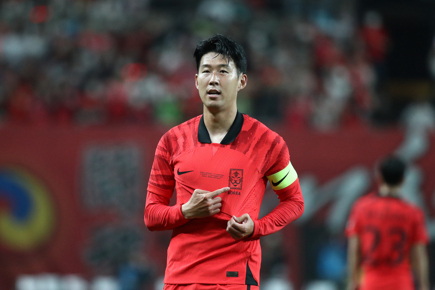 a korean soccer player in a red soccer jersey