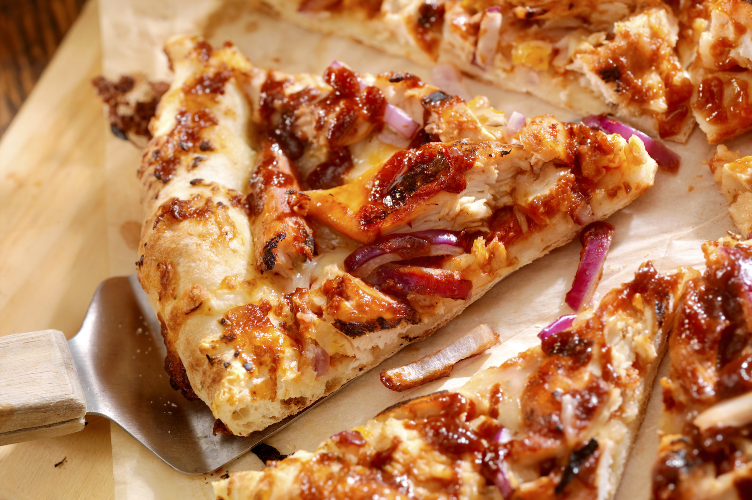 a slice of bbq chicken pizza with red onions