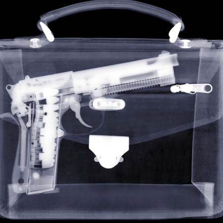 An x-ray of a handbag showing a gun inside. According to TSA, American travelers are still bringing guns to airports despite massive fines.