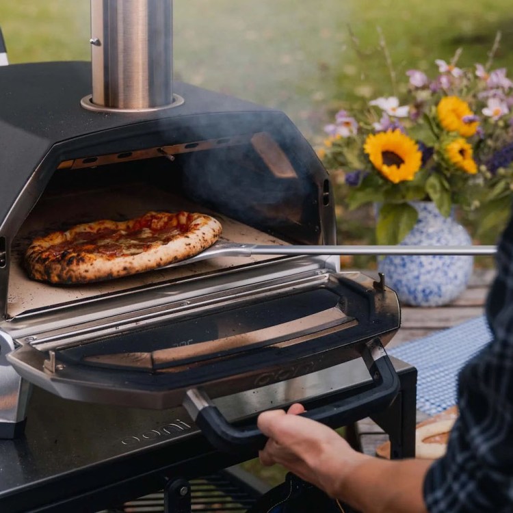 A pizza going into the Ooni Karu 16 Multi-Fuel Pizza Oven, now on sale for Black Friday