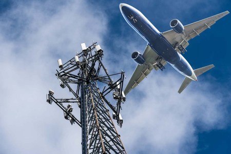 Mobile phone cell tower with 5G on the C Band frequencies with aircraft coming to land. Airlines worried about interference with plane altimeter, but the EU has opened the door for passenger use of 5G tech on properly equipped planes.