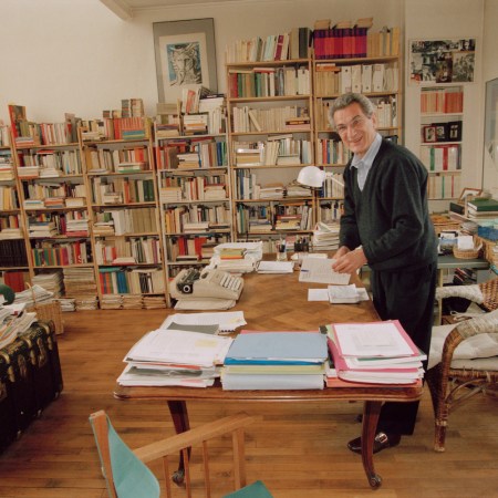 An Italian writer standing in a home library.