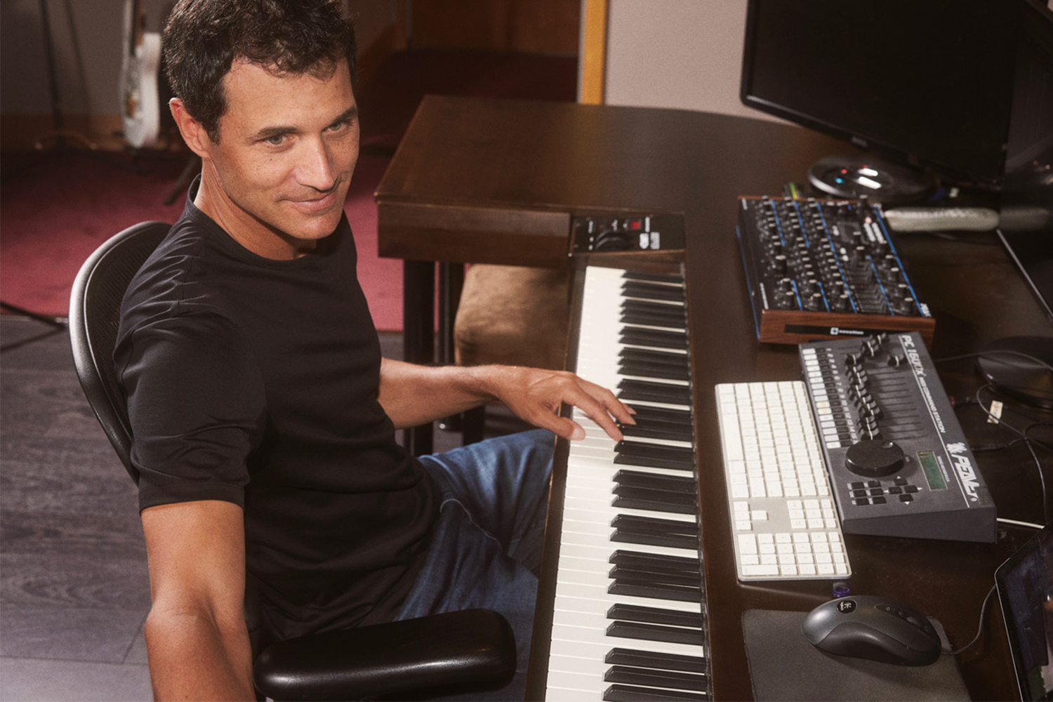 Ramin Djawadi, composer for "House of the Dragon" and "Game of Thrones," sits at a keyboard in his music studio