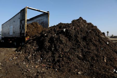 Raw materials are dumped from a tractor trailer that will be turned into feedstock compost at the Recology Blossom Valley Organics compost facility in Lamont, CA.