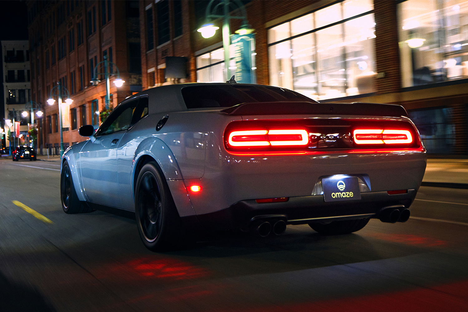 The rear end of a Dodge Demon, one that's being given away by Omaze, shown on the road at night