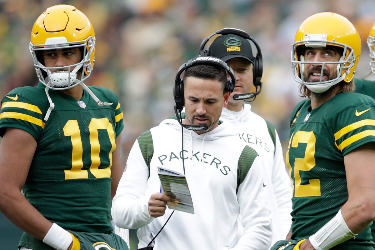 Aaron Rodgers talks with Packers head coach Matt LaFleur as Jordan Love listens