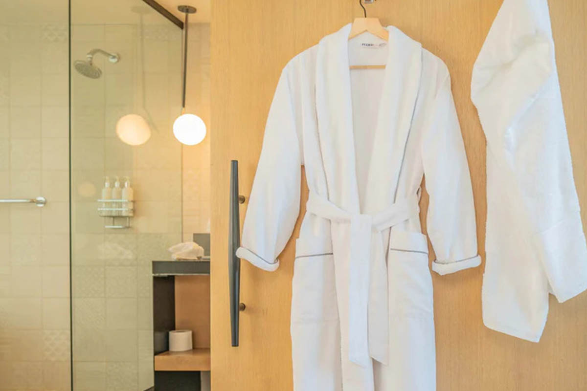FluffCo hotel robe and towels in a bathroom