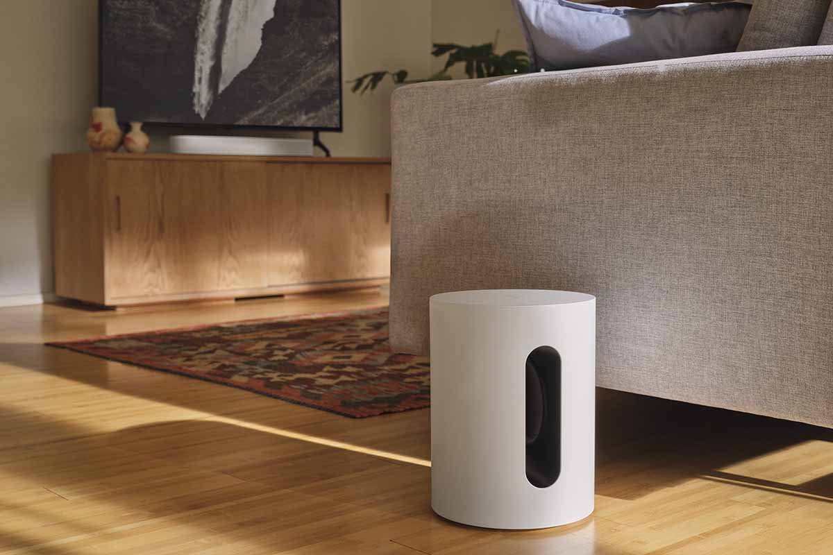 A Sonos Sub Mini next to a couch in a living room