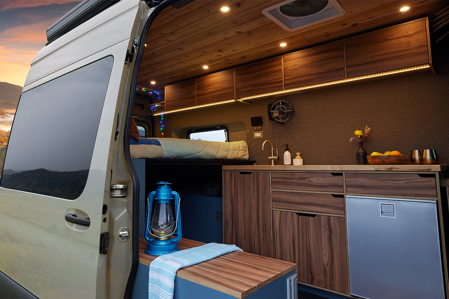 The door open on a camper van being given away by Omaze, with a view to the homey interior with a bed and kitchen