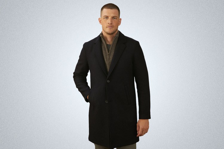 a model in a navy Billy Reid Peacoat on a grey background
