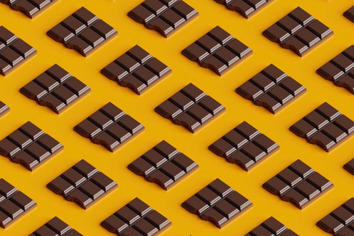 Seamless pattern of bitten chocolate bars on a yellow background