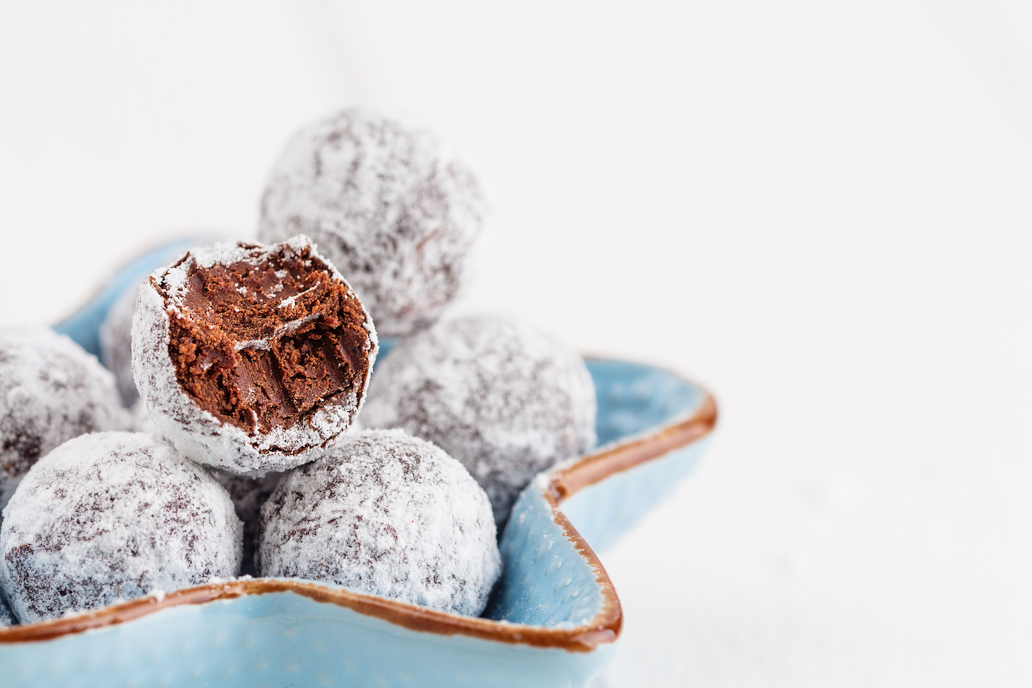chocolate truffles rolled in powder sugar in a star-shaped bowl