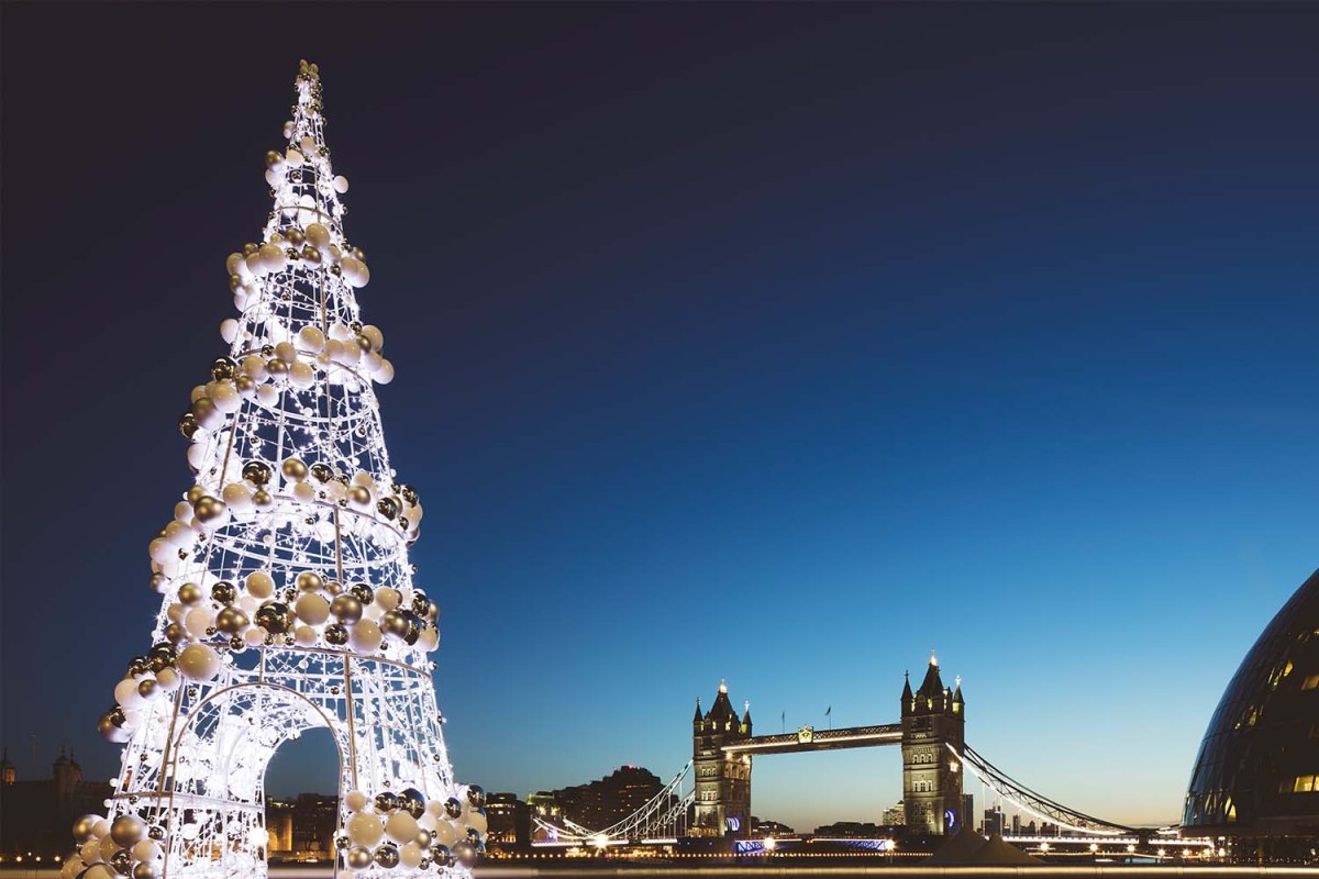 UK, London, Tower Bridge at twilight with illuminated Christmas tree in the foreground