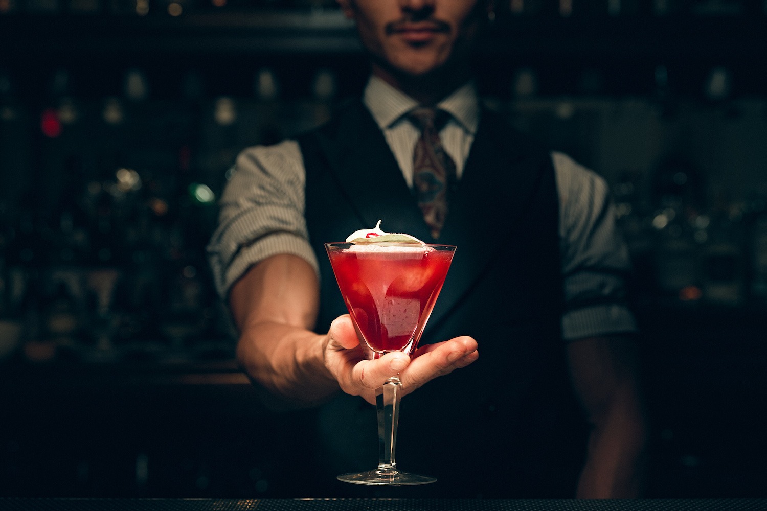 bartender at NR in new york city holding a red cocktail