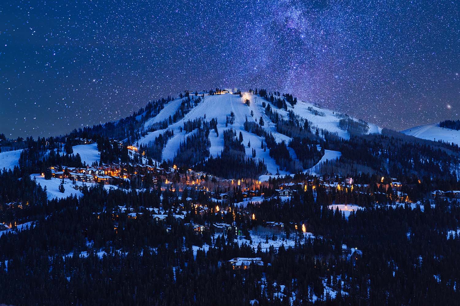 A snowy mountain at night in Park City, one of the best winter vacation spots for skiiers