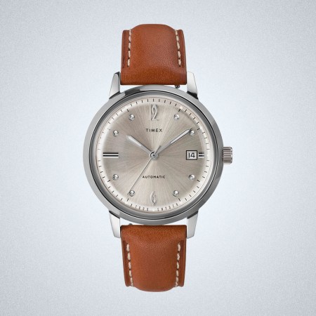 a silver and leather Timex watch on a grey background
