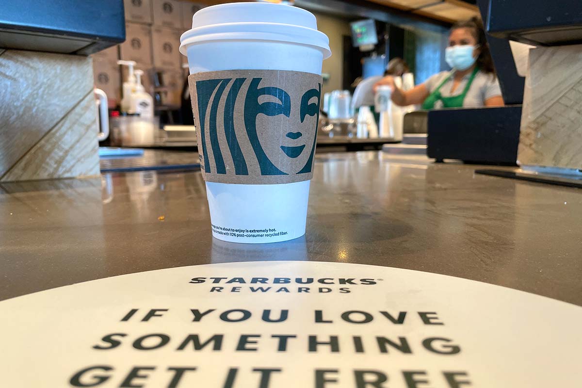 The Starbucks logo is displayed on a cup at a Starbucks store on October 29, 2021 in Marin City, California. Changes to Starbucks Rewards mean most customers will need to earn more stars to earn free coffee.