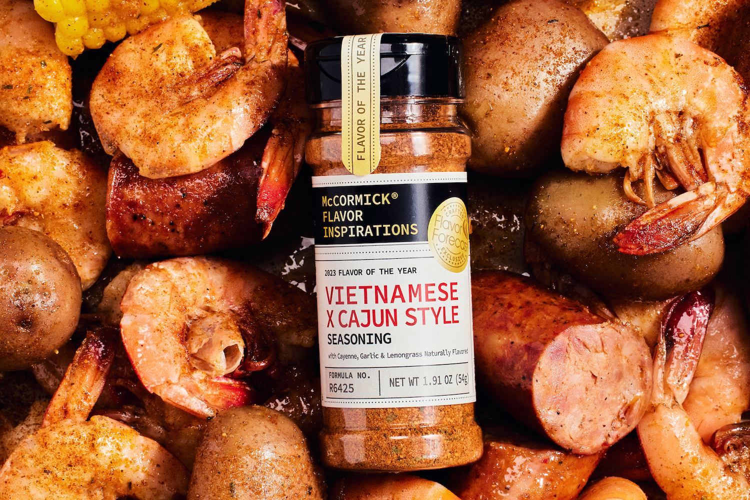 mccormick vietnamese x cajun style seasoning sitting on top of corn, sausage and shrimp