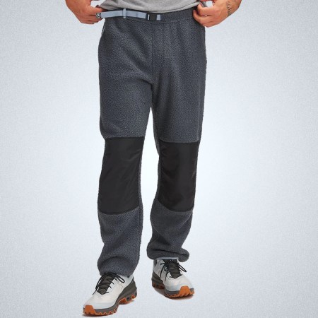 a model in a pair of grey panneled Backcountry fleece pants on a grey background