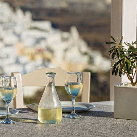Table with a bottle of white wine and glasses in santorini