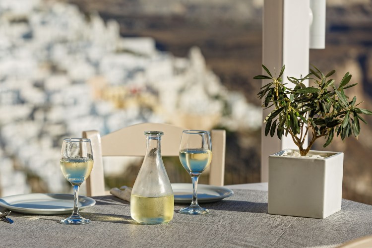Table with a bottle of white wine and glasses in santorini