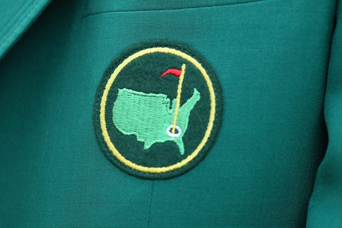 A Masters logo on a green jacket worn by a member of Augusta National Golf Club.