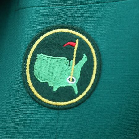 A Masters logo on a green jacket worn by a member of Augusta National Golf Club.