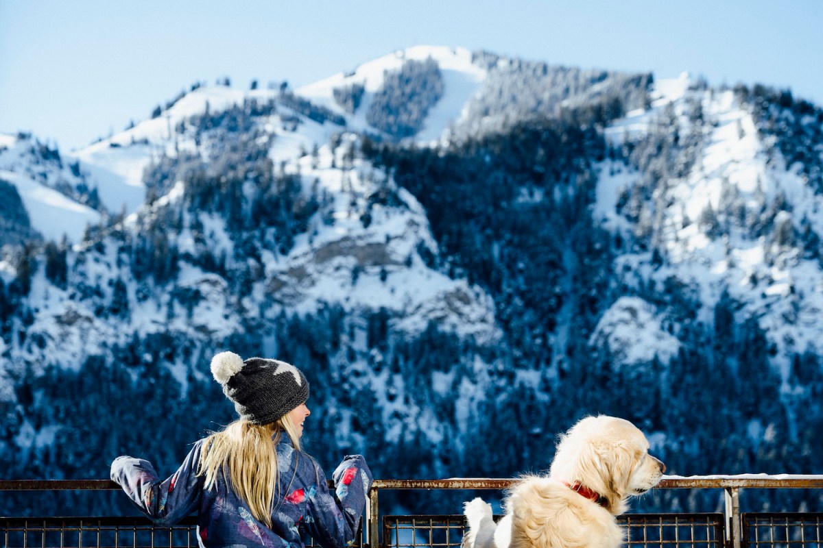 a woman and her dog looking at a mountain at limelight ketchum in idaho