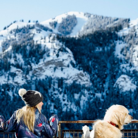 a woman and her dog looking at a mountain at limelight ketchum in idaho