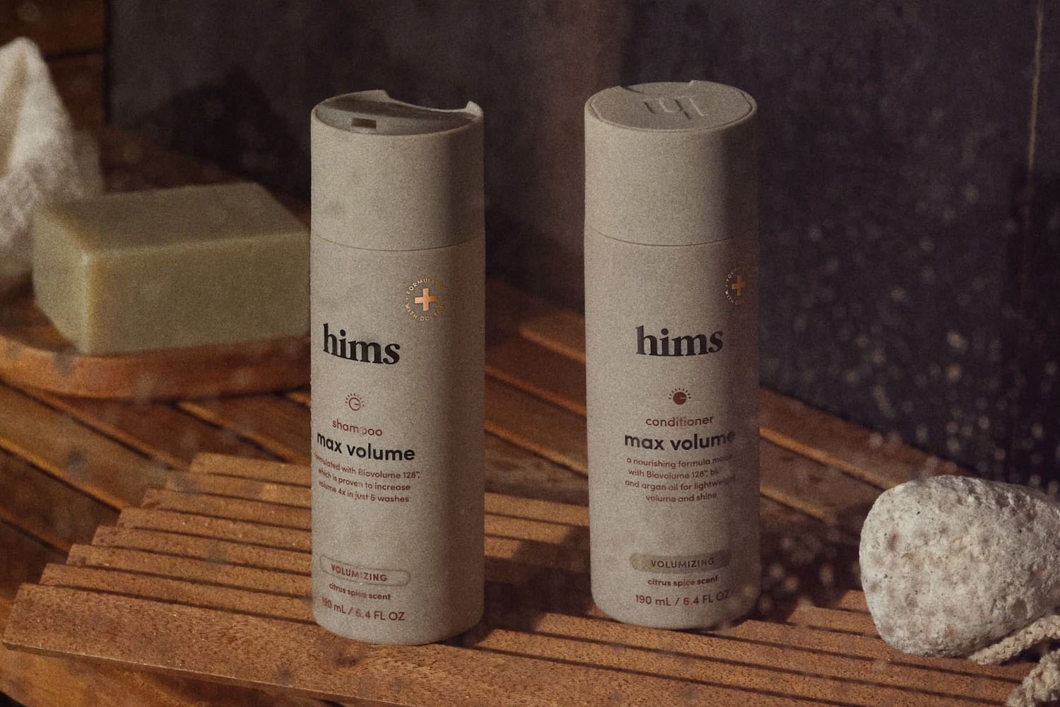 two bottles of Hims Max Volume Shampoo and Conditioner in a wooden bathroom