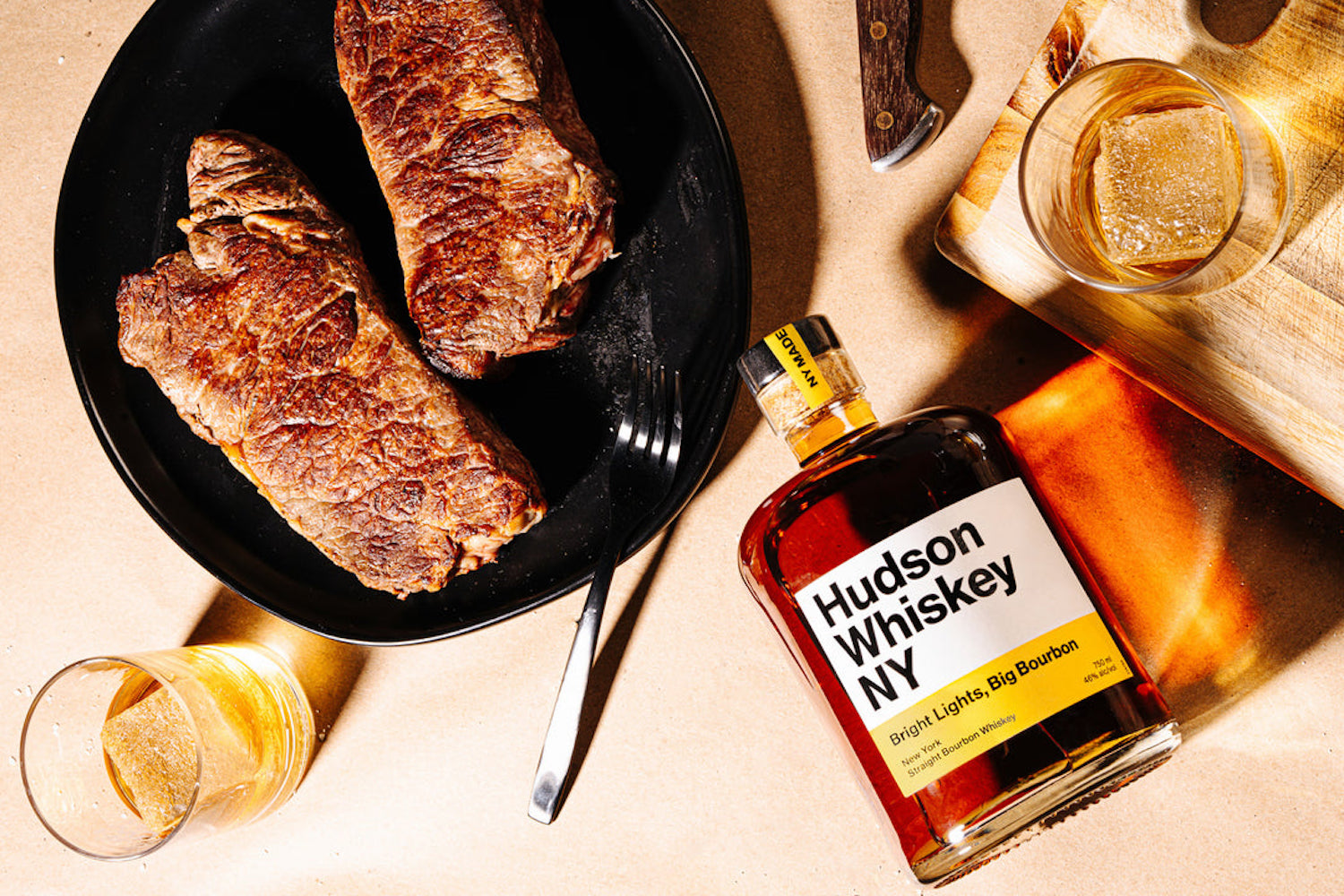 a new york steak and whiskey on a wooden background