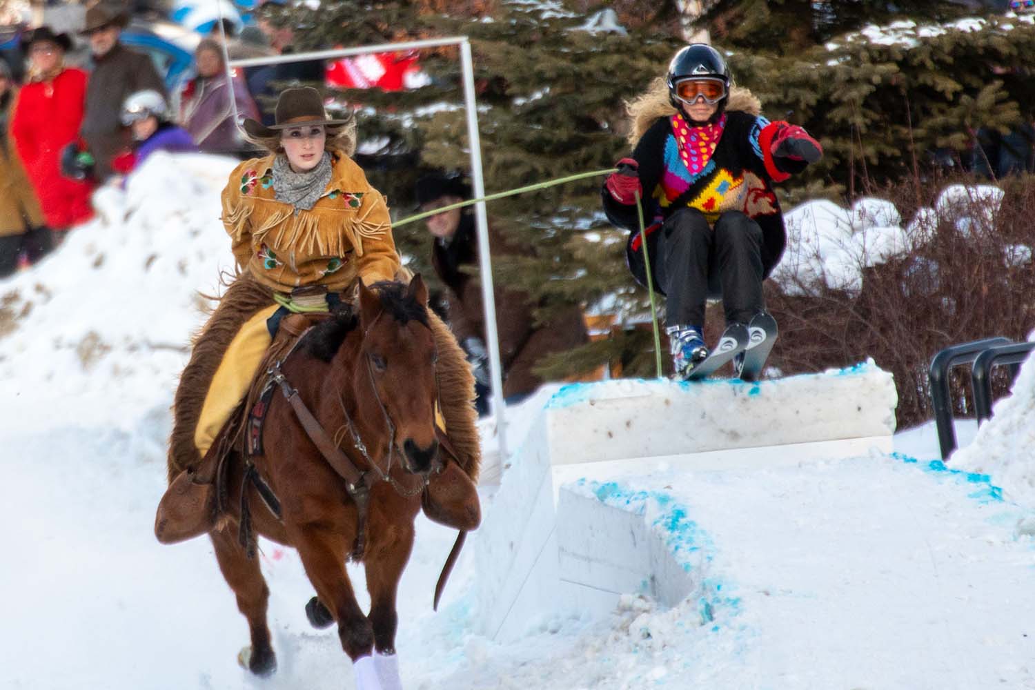 Up close of a horse and rider pulling a skiier