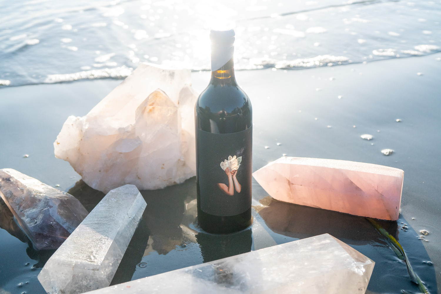a bottle of Crystal Visions Cabernet Sauvignon wine on the shore surrounded by crystals 
