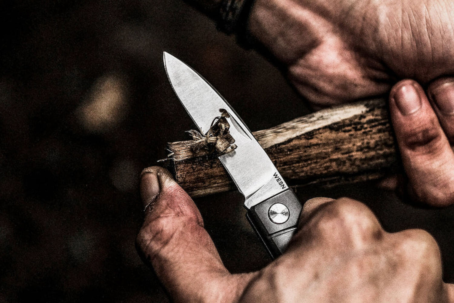 a model carving wood with a WESN EDC Knife