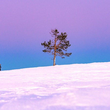 A woman snowshoeing in Finland at dusk.