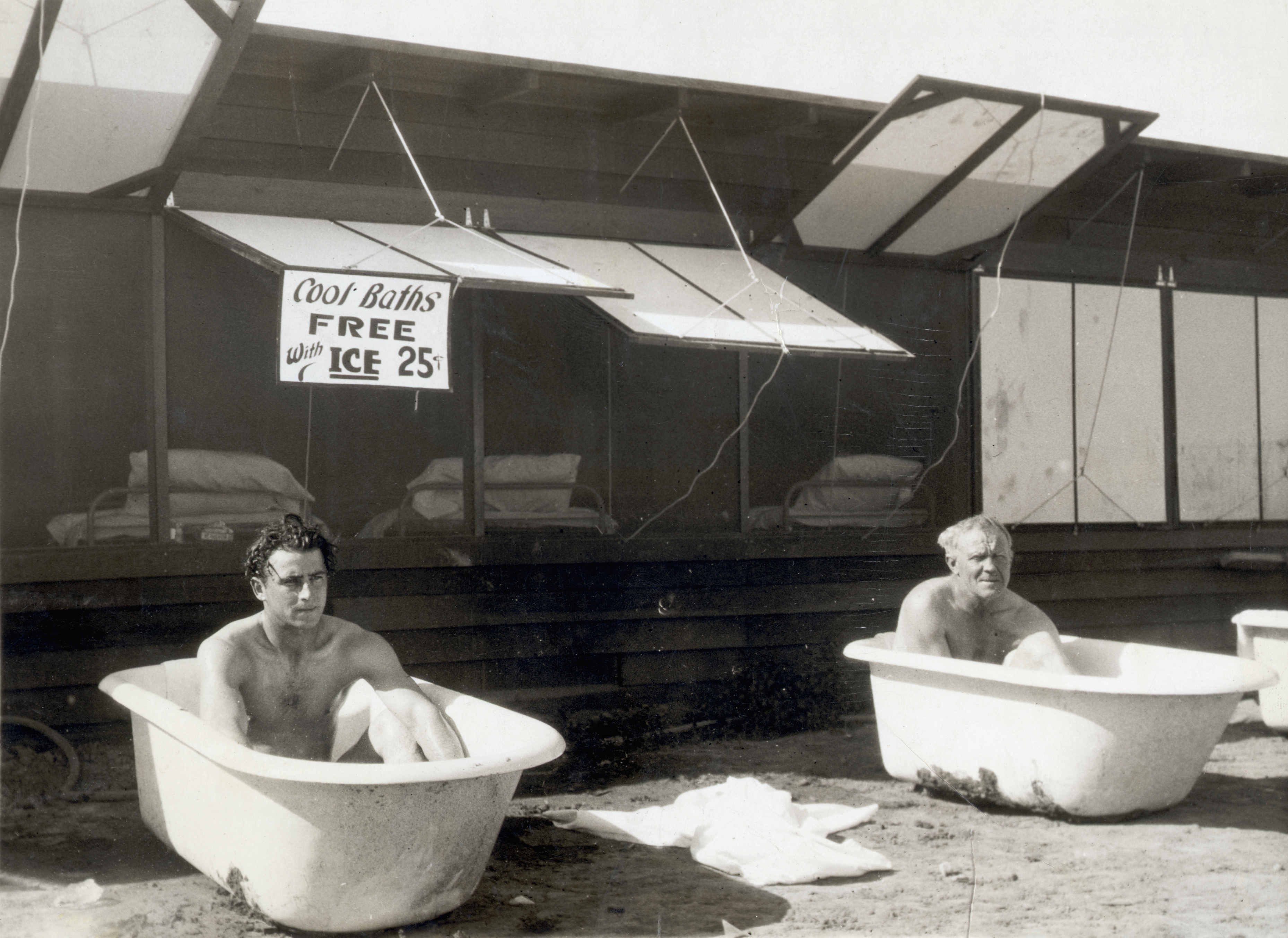 Two men sitting in bathtubs filled with ice. Apparently cold plunge pools are now sites for business meetings.