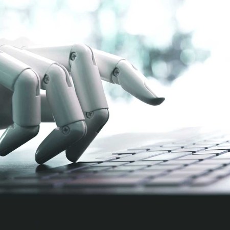 A robot hand using a keyboard. Articles on CNET written by artificial intelligence recently appeared with numerous mistakes.