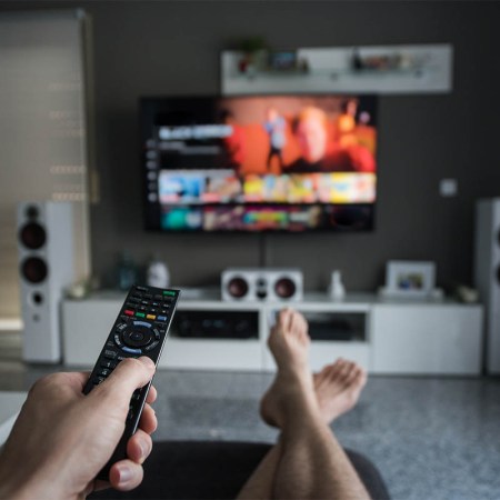 A young man is browsing through television channels with a remote control. Figuring out your home theater sound system isn't as daunting as it sounds - we explain the difference between 5.1, 7.1, Dolby Atmos and more