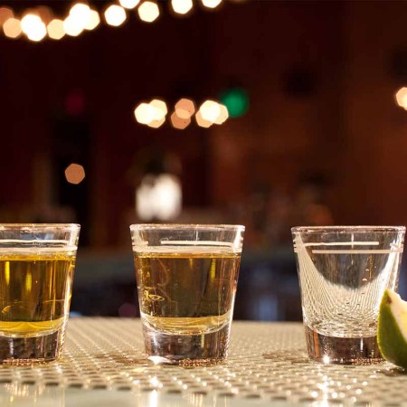 Shots of various types of tequila on bar with lime wedge. While tequila sales continue to shine, other spirits categories are hitting a ceiling.