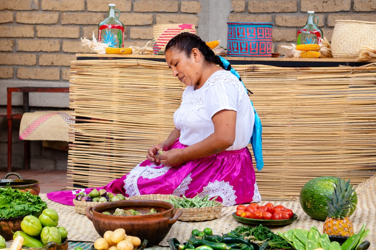 Mimi Lopez Hernandez sitting around bowls of traditional oaxacan ingredients