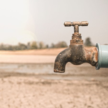 a rusty faucet in front of a desert landscape