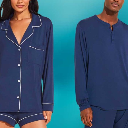 A man and woman model wearing navy Eberjey pajamas