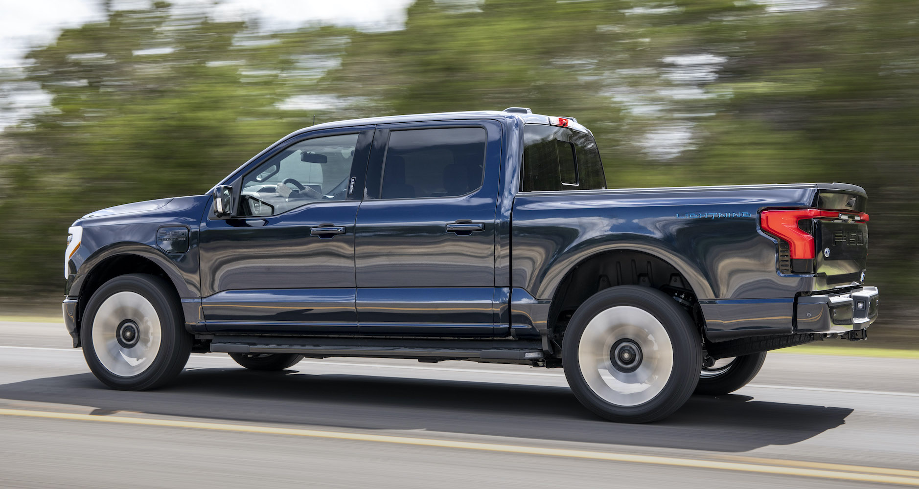 The Ford F-150 Lightning Platinum, the top trim model of the electric pickup truck, driving down the road. Here's our review.