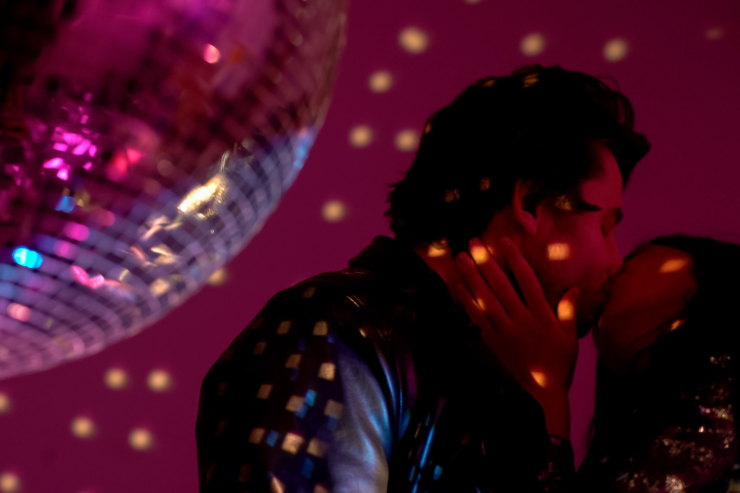 Playful drunk couple passionately kissing at disco party in night club