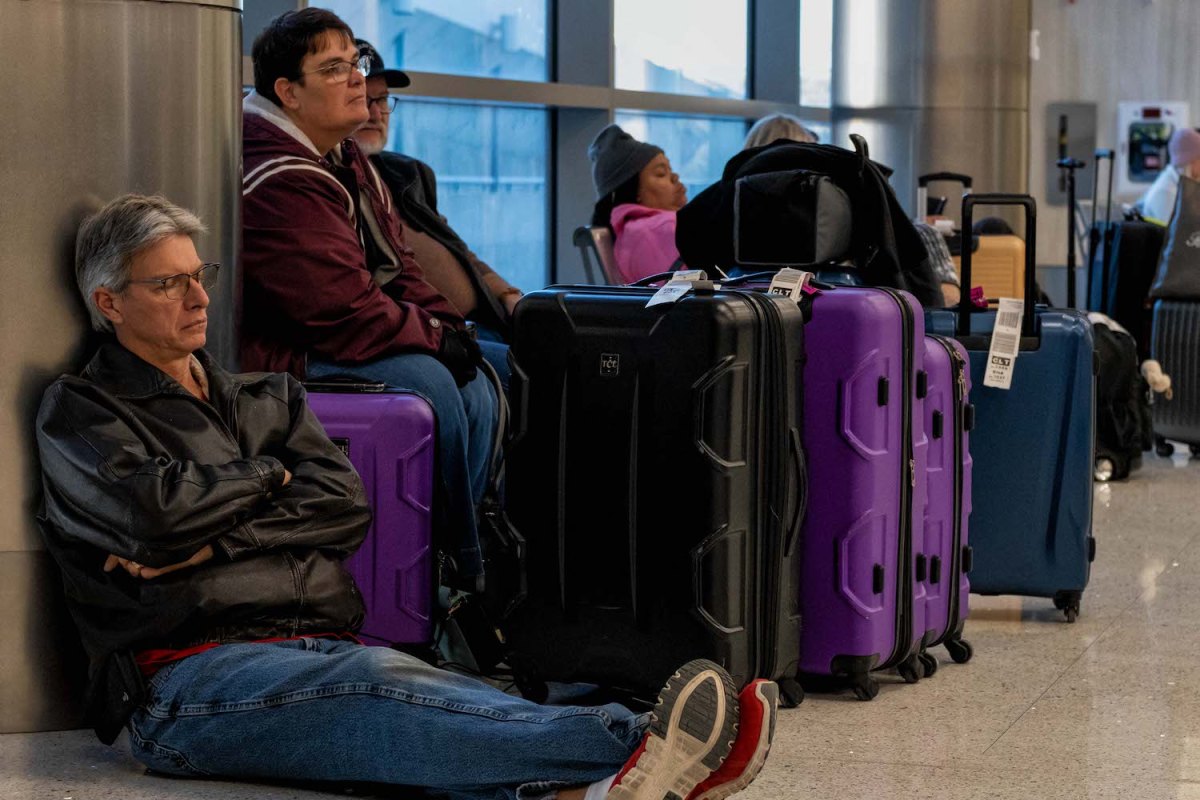Travelers wait next to their luggage near the Southwest Airlines baggage claim area at the Nashville International Airport