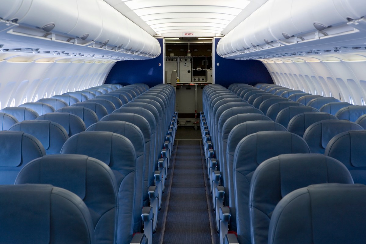 rows of blue seats in The empty cabin of an airplane