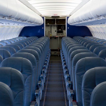 rows of blue seats in The empty cabin of an airplane